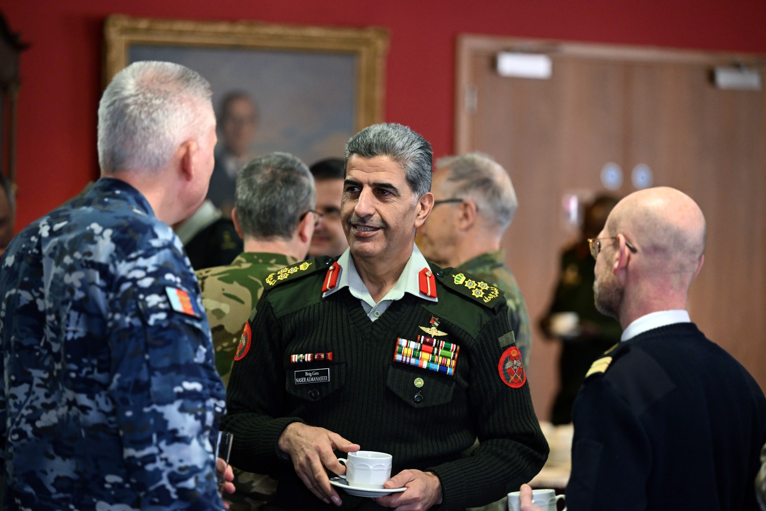 International Defence Attaches talking while drinking coffee.
