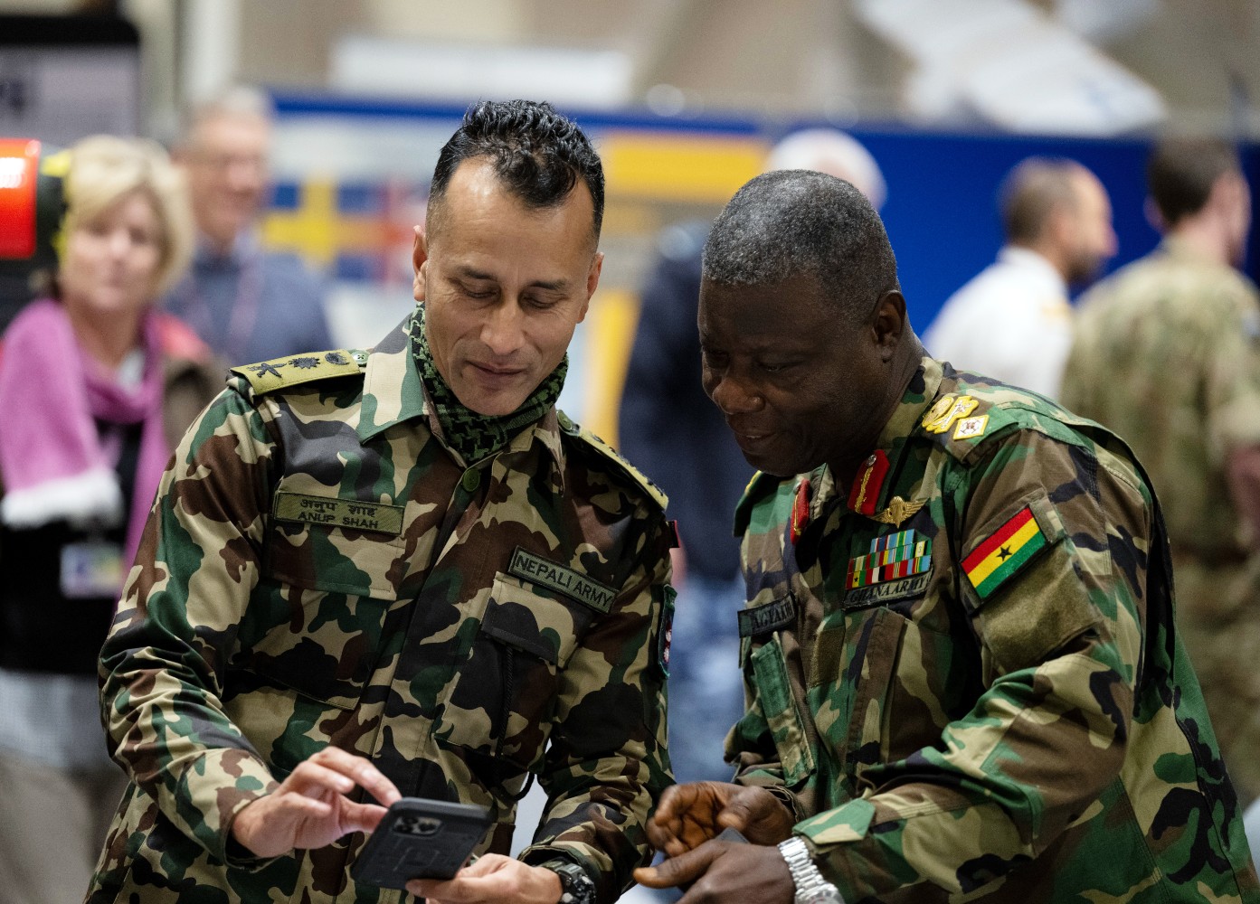 Nepal and Ghana Defence Attaches looking at a phone and smiling.