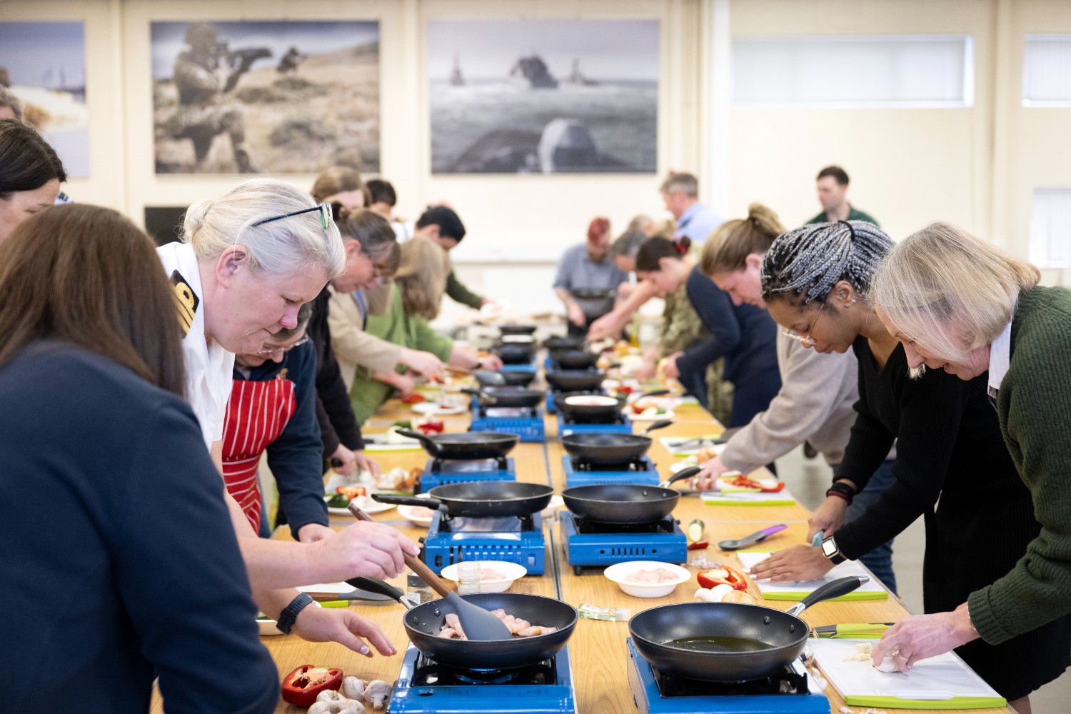 Long table with participants cooking at their individual stations.