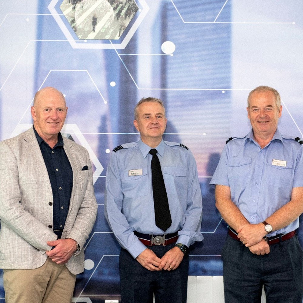 Australian Defence Force, Chief of Joint Capabilities, Lt Gen JJ Frewen and Deputy Commandant of the Defence Academy UK, Air Cmdre Hamish Cormack stood in front of a cyber banner.