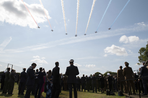 Red Arrows flying overhead with Defence Academy personnel observing.