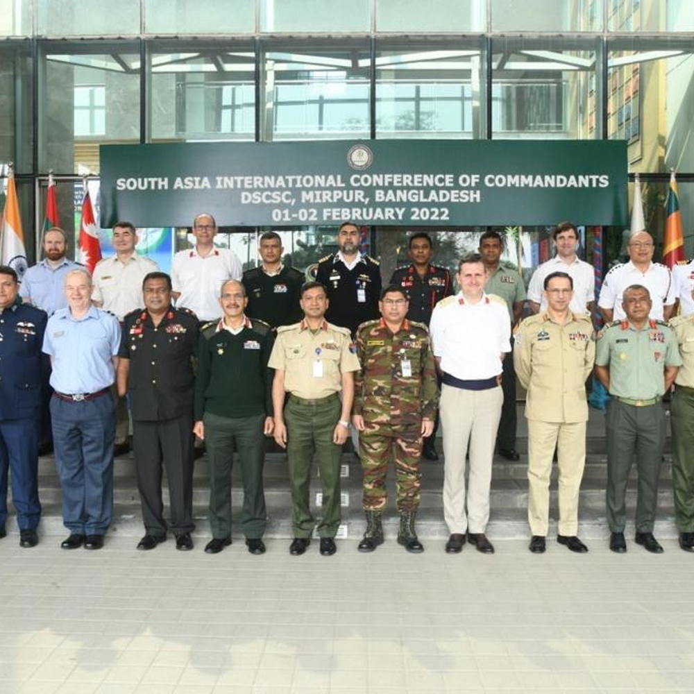International delegates stood outside the Defence Services Command and Staff College, Bangladesh surrounded by national flags of those in attendance. 