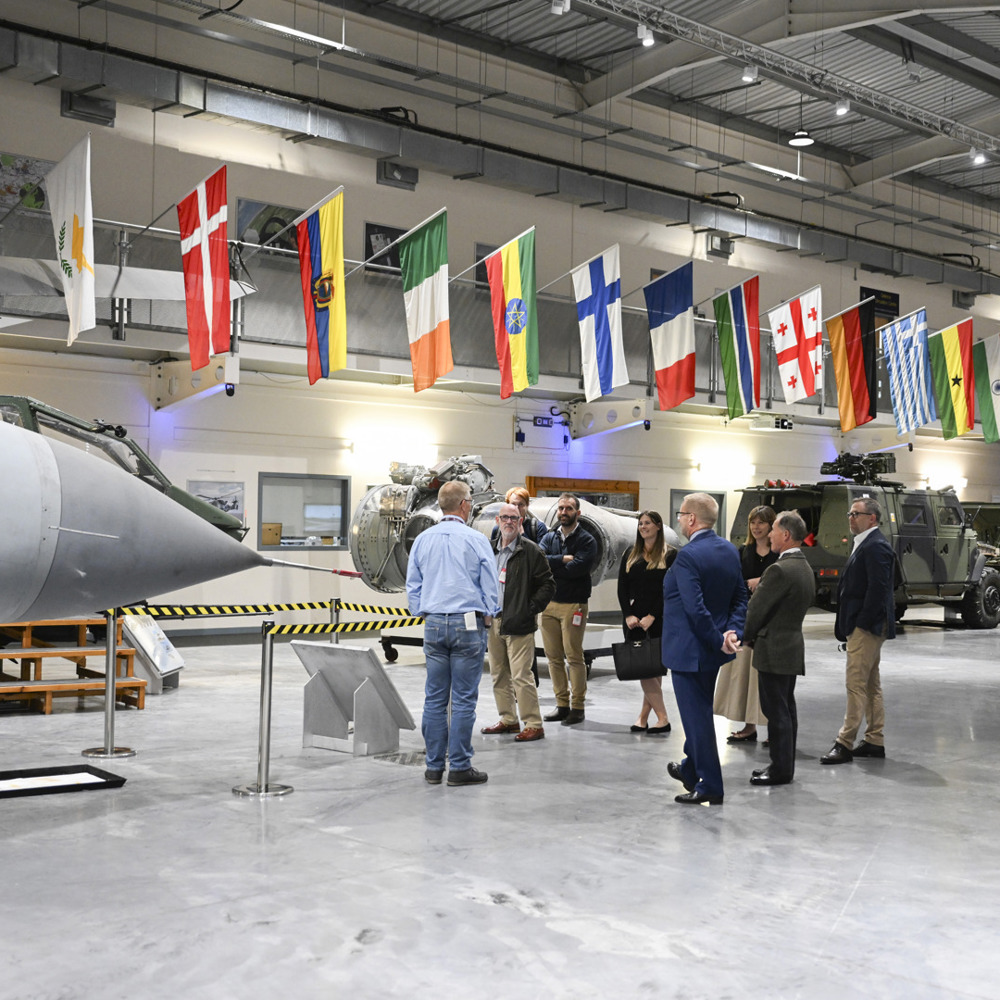 Visitors being given a talk surrounded by military equipment. 