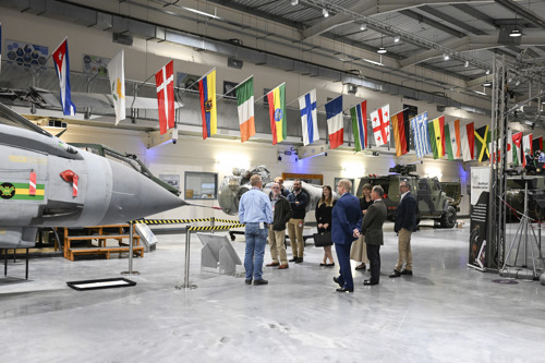 Visitors being given a talk surrounded by military equipment. 