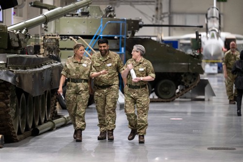 Three members of the AFPS wearing military combat uniform, walking through the Defence College for Military Capability Integration.  