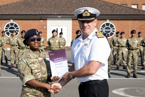 Female officer cadet receiving a certificate for 'best overall student