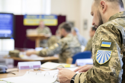 A close angle shot of a Ukrainian Chaplain with his national badge on his sleeve. 
