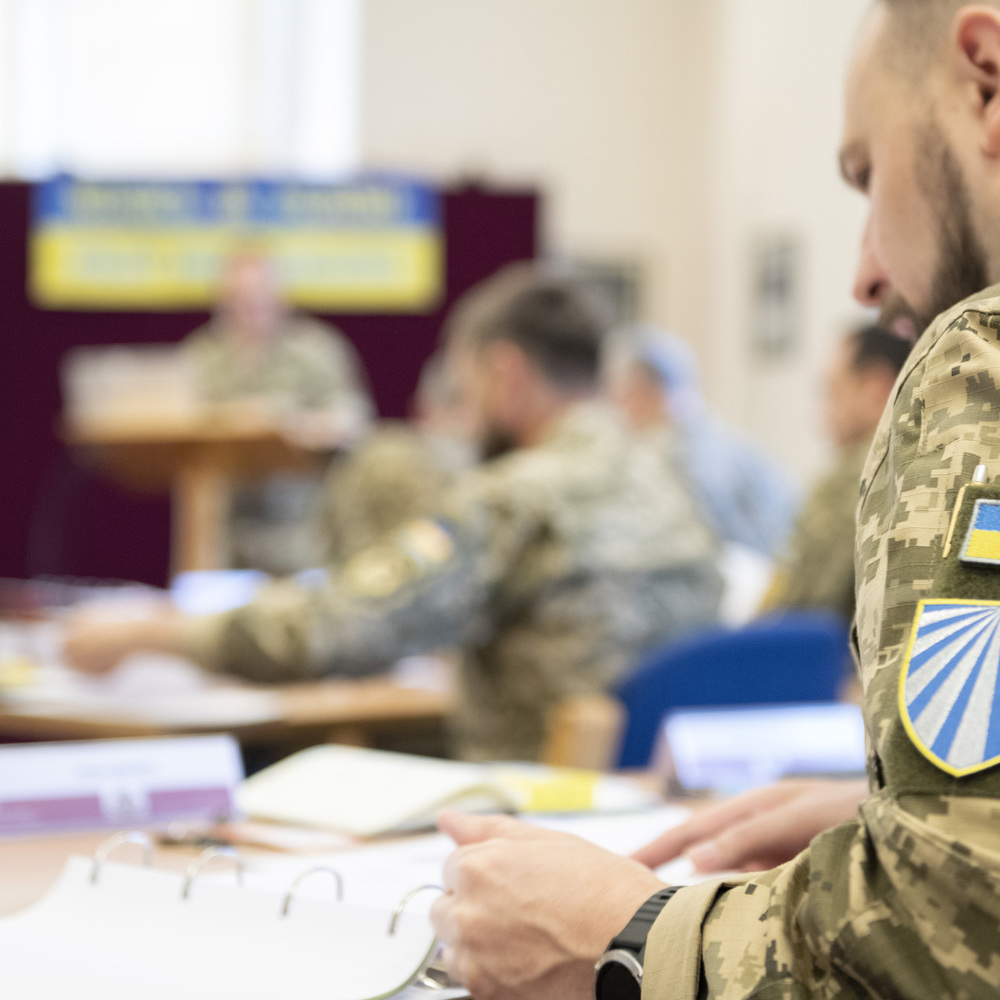 A close angle shot of a Ukrainian Chaplain with his national badge on his sleeve.