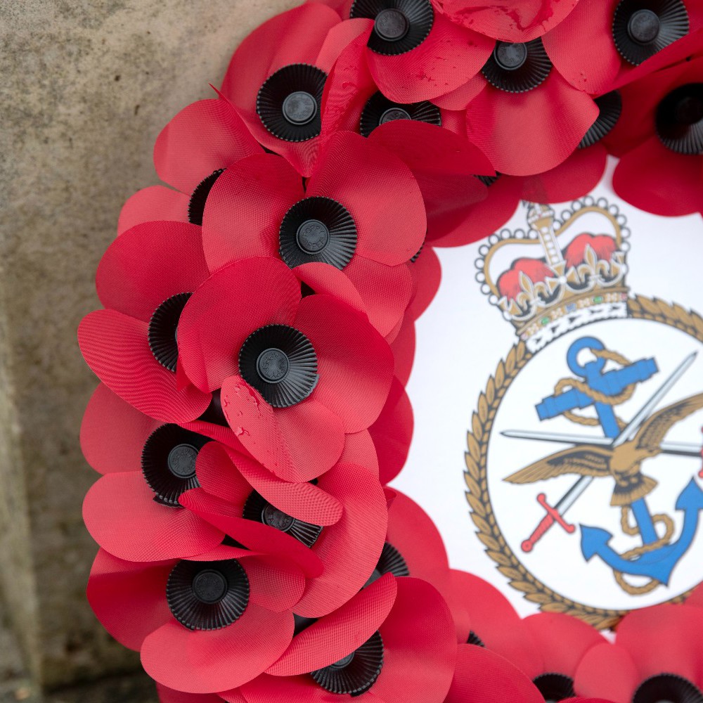 Close up of poppy wreath with Defence Academy crest in the centre.