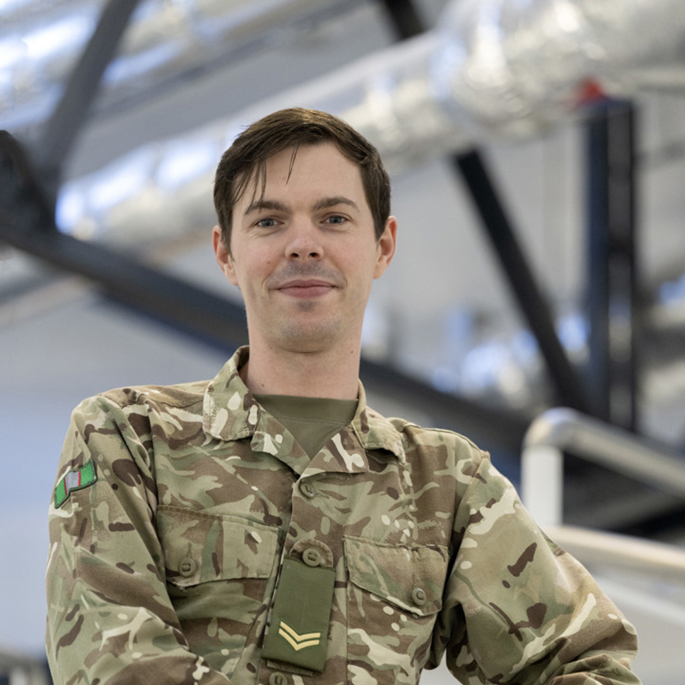 A soldier dressed in MTPs stood on a spiral staircase. 