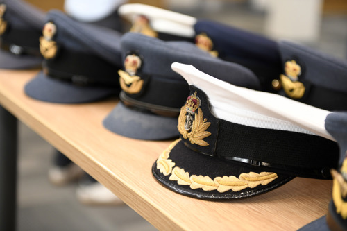 A selection of Royal Air Force uniform caps aligned in a row on a table