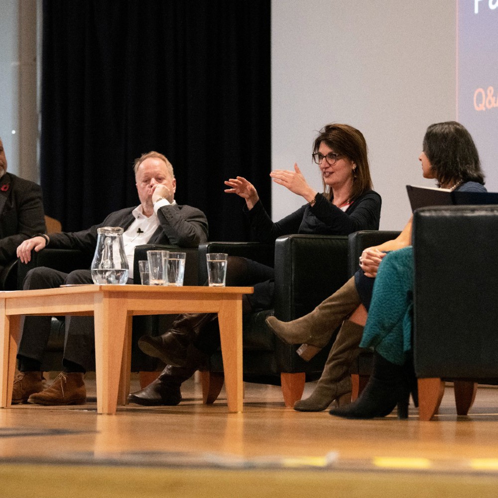 A group of individuals seated on chairs on stage for a Q&A session.