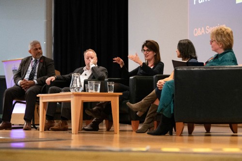 A group of individuals seated on chairs on stage for a Q&A session.