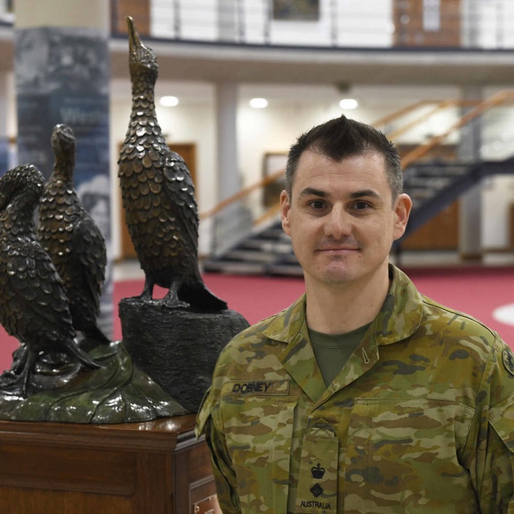 Australian Military officer stood next to Cormorant statue.