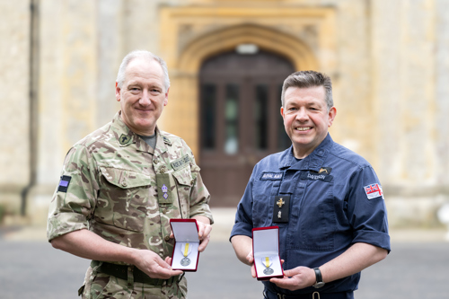 An Army and Navy padre holding their Ukrainian medals in their presentation boxes.