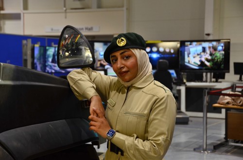 A woman leaning on an armoured vehicle