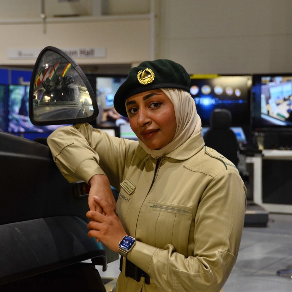 A woman leaning on an armoured vehicle