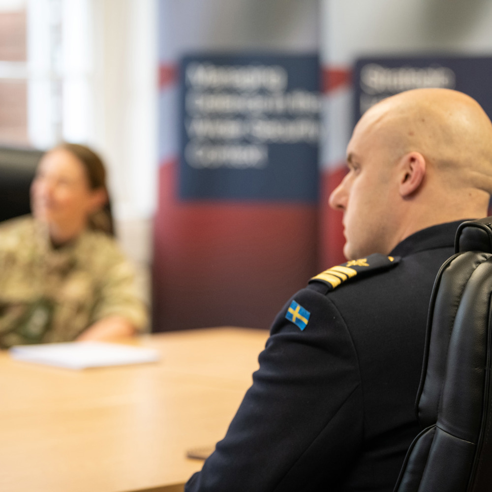Over the shoulder of a Swedish officer showing the Swedish flag on his uniform.