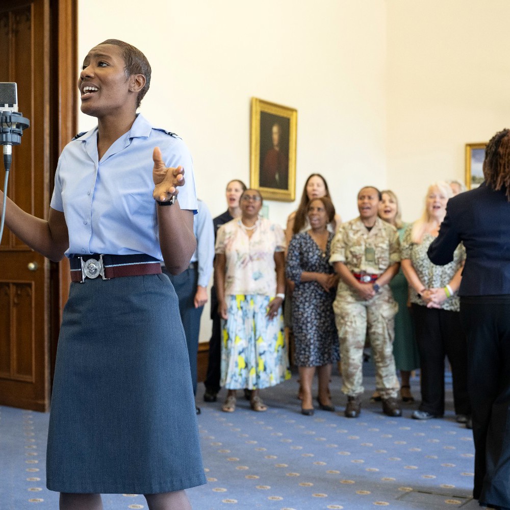 Female RAF officer singing with rest of choir in the background.
