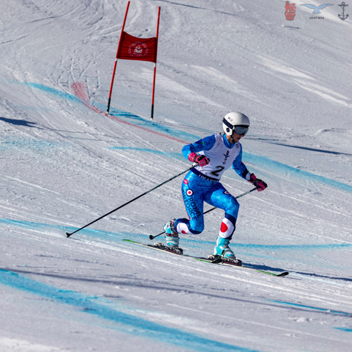 Female RAF officer skiing on snowy slope.