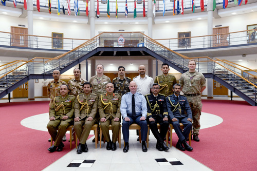 A group of Omani officers stood in the Forum surrounded by international flags.