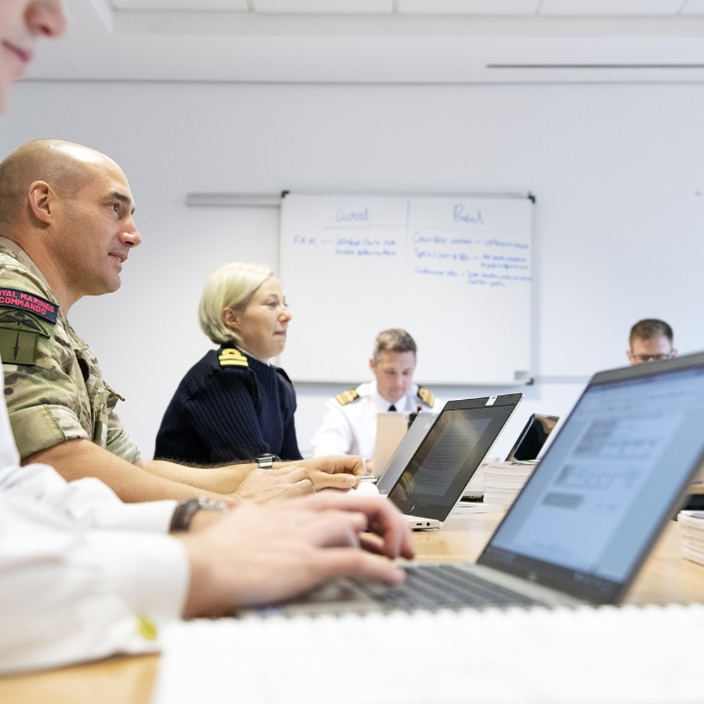 Students in Service uniform seated in a classroom working on laptops