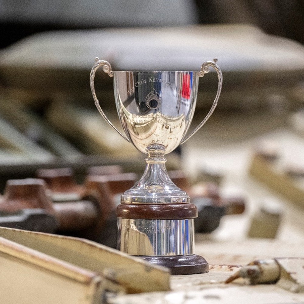 A shiny metal trophy with 'Kavanagh Cup' inscribed. 