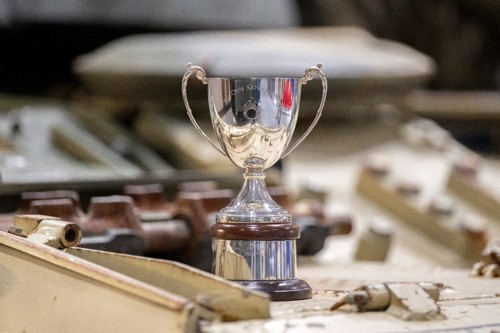 A shiny metal trophy with 'Kavanagh Cup' inscribed. 