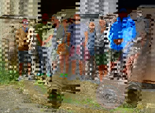 A group of people stood next to a large historic canon.