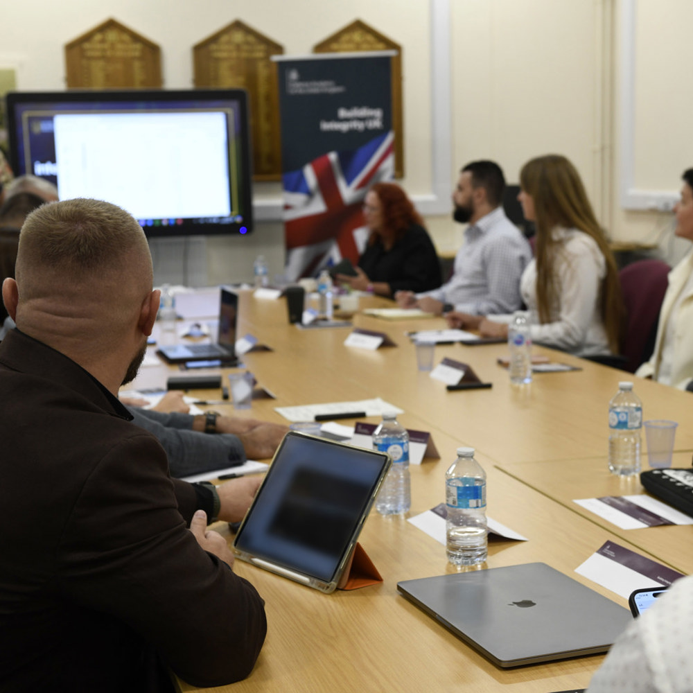 Students sat around a table in a classroom being presented to.