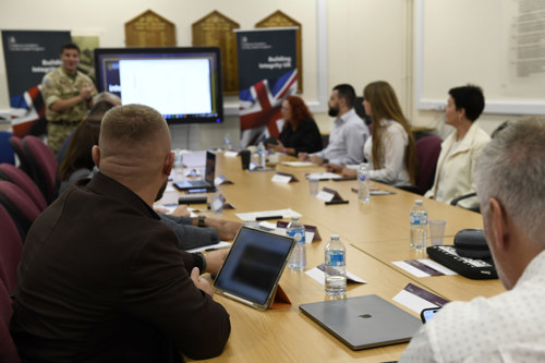 Students sat around a table in a classroom being presented to.
