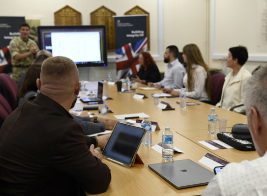 Students sat around a table in a classroom being presented to.