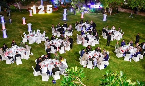 An outside floorplan with round dining tables on grass.