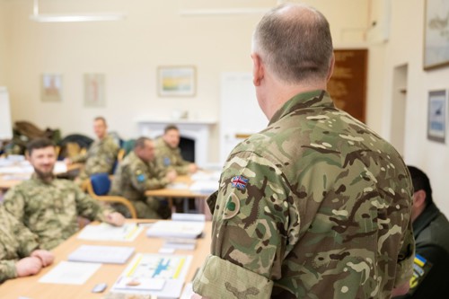 A UK army officer teaching a classroom of military officers.