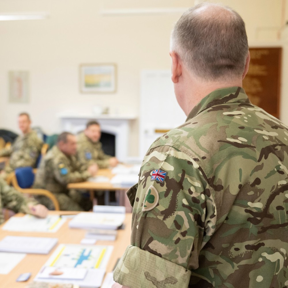 A UK army officer teaching a classroom of military officers.