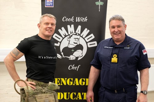 Royal Marine and Navy officer stood in front Commdao Chef banner.