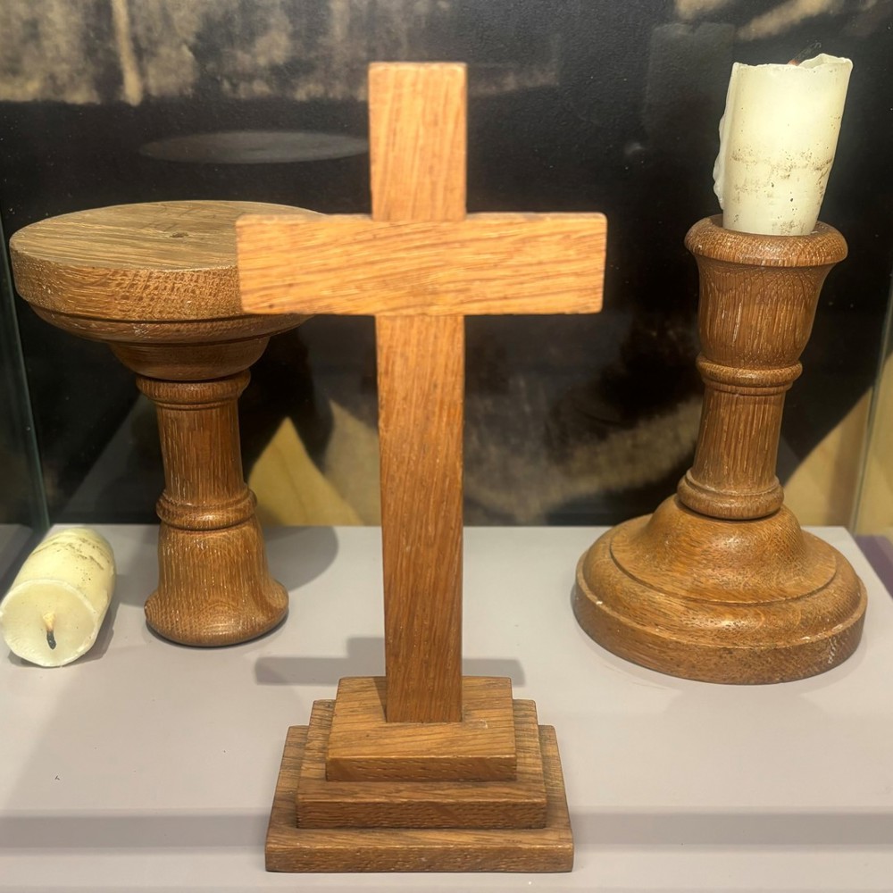 A crucifix and candlestick in a museum display.