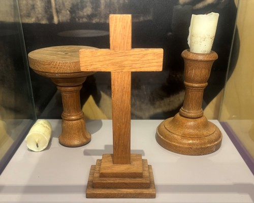 A crucifix and candlestick in a museum display.