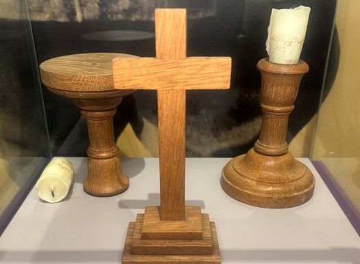 A crucifix and candlestick in a museum display.