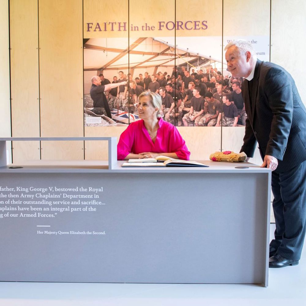 HRH The Countess of Wessex sat in front of an exhibit inside the RAch museum with Revd Totten